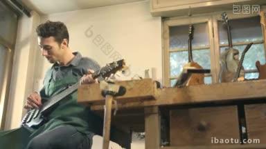 成年意大利男子在工作中作为工匠在车间演奏和测试新的贝斯吉他和乐器